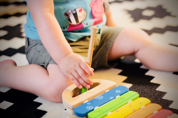 Toddler playing with a colorful xylophone toy