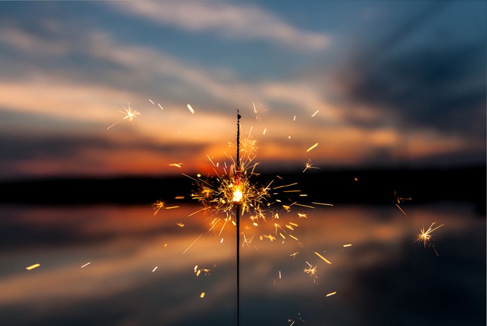 Sparkler at sunset over water