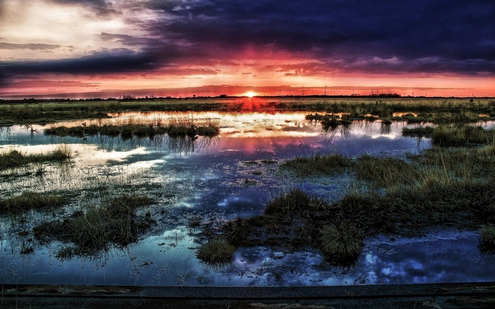 Sunset over marshland with reflections