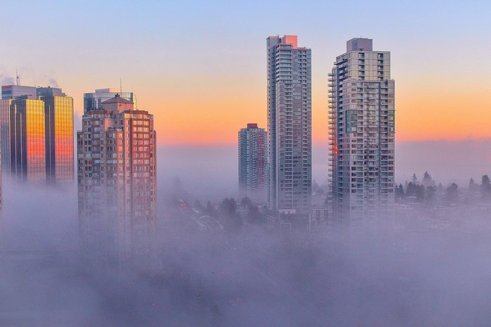 Skyscrapers emerge from fog at sunrise