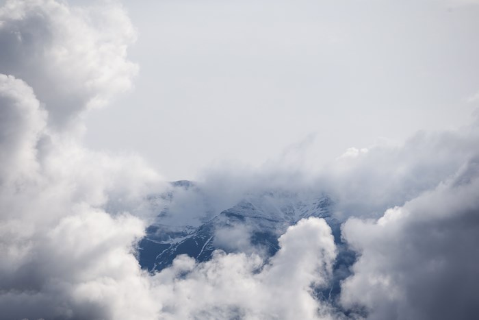 Snow-capped mountain peaks shrouded in clouds