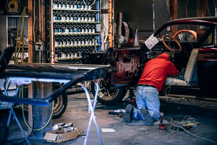 Man restoring a vintage car in a workshop
