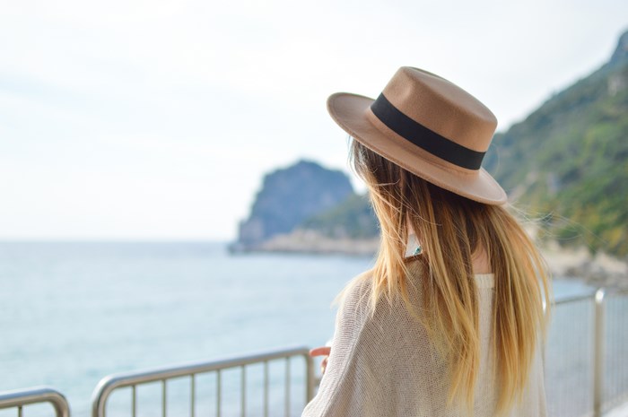 Woman in hat looking out at the sea