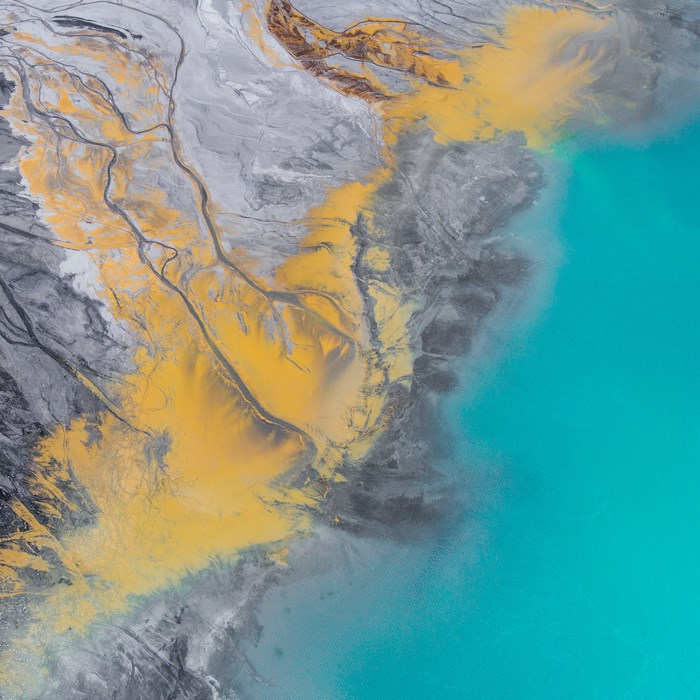 Aerial view of mining waste and turquoise water