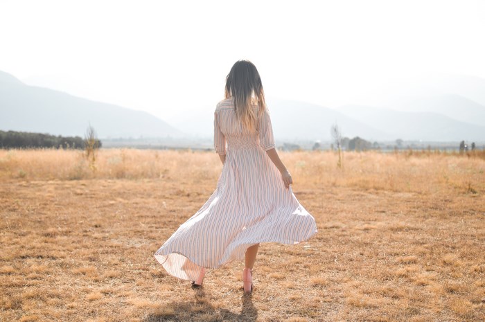 Woman in a striped dress in a dry field