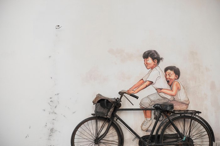 Two children riding a bicycle mural