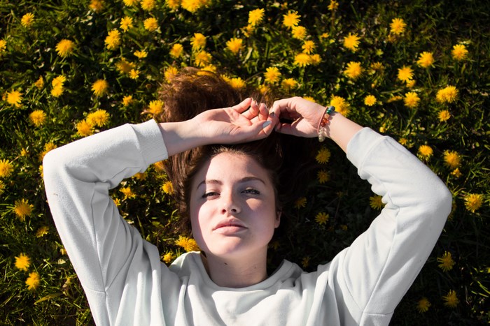 Woman lying in a field of dandelions