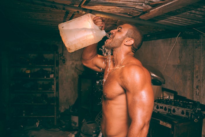 Muscular man drinking water after workout