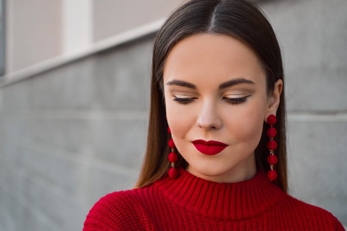 Woman with Red Lipstick and Earrings in Red Sweater