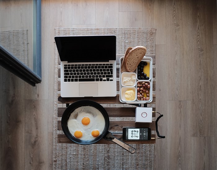 Macbook, fried eggs, and breakfast on a tray