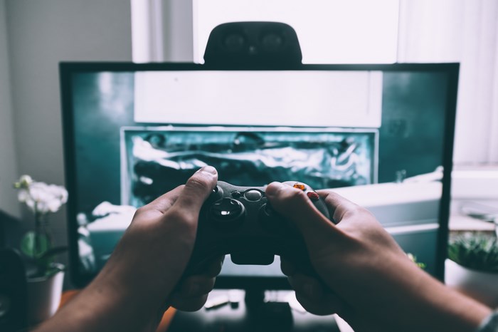 Person playing video game with Xbox controller