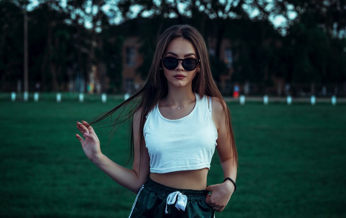 Woman in sunglasses and tank top on grass