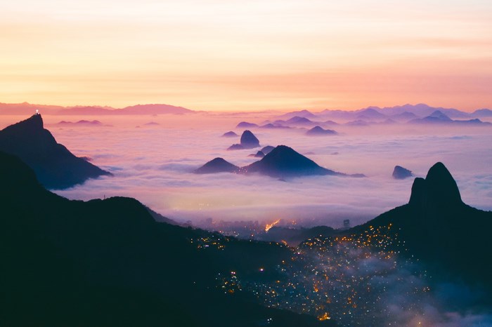 Rio de Janeiro favela and mountains above clouds at sunrise