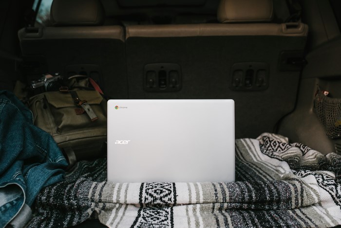 Acer Chromebook in a car trunk with backpack and blanket