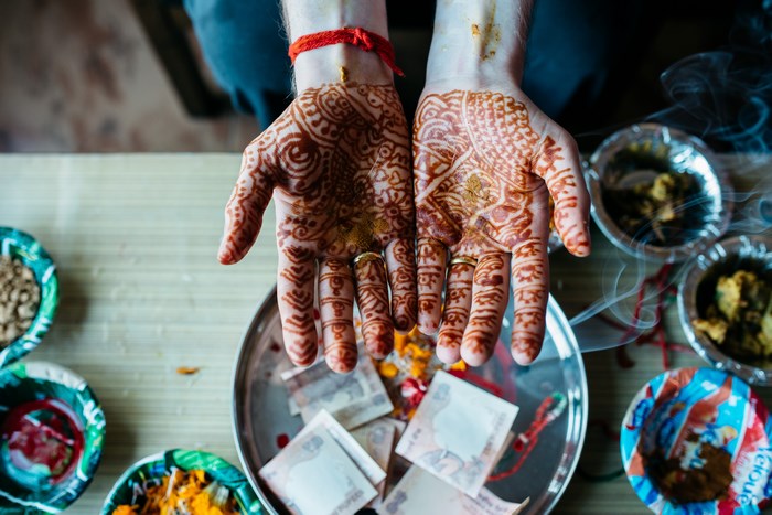 Hands with Henna and Money at an Indian Wedding