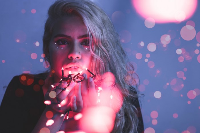 Woman with blonde hair holding fairy lights