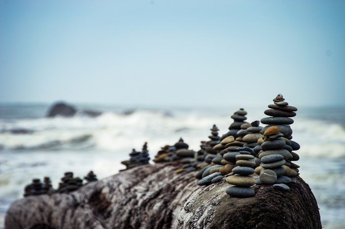 Stacked stones on a log by the ocean