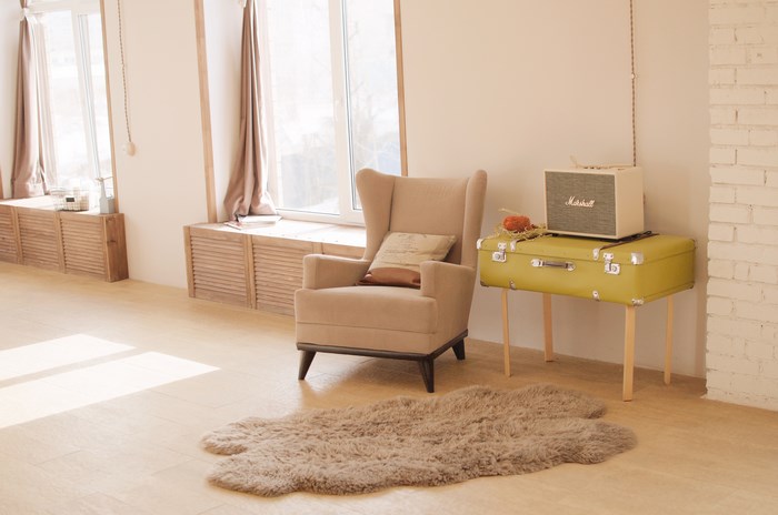 Minimalist interior with armchair, suitcase, and Marshall speaker