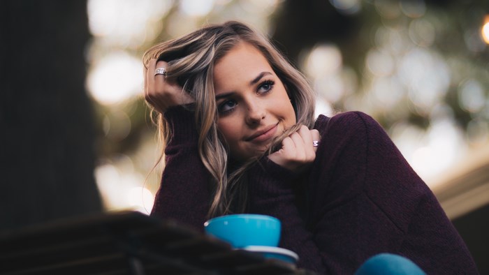 Woman in sweater with blue cup