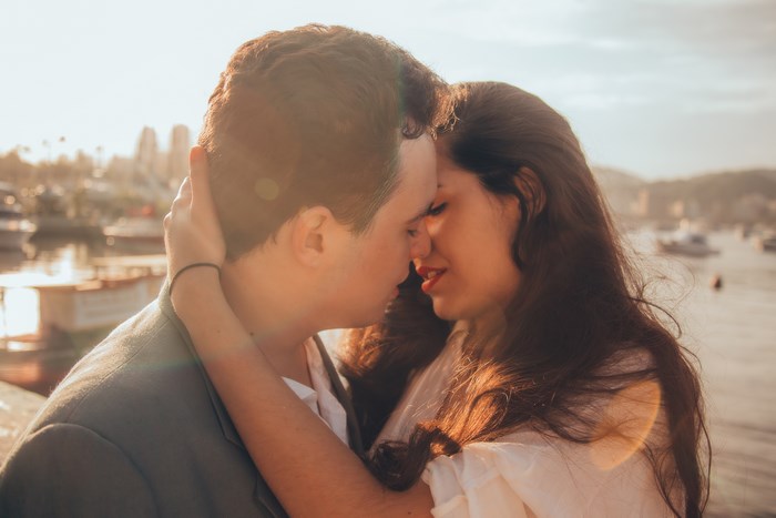 Couple embracing and kissing at sunset