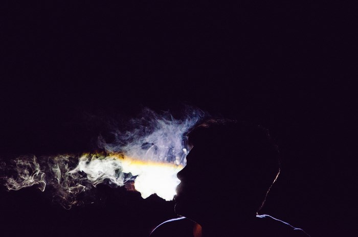 Silhouette of a man smoking in the dark