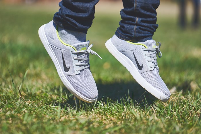 Nike sneakers jumping on grass