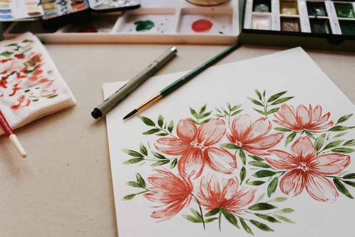 Watercolor painting of flowers with art supplies