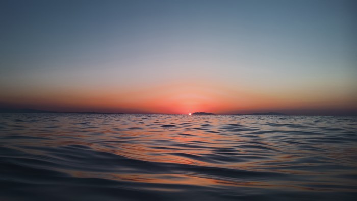 Sunset over the ocean with a distant island