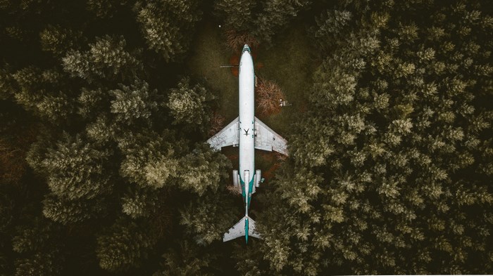 Abandoned airplane in a dense forest from above
