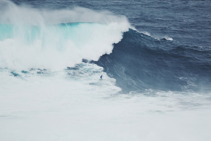Surfer riding a massive wave in the ocean