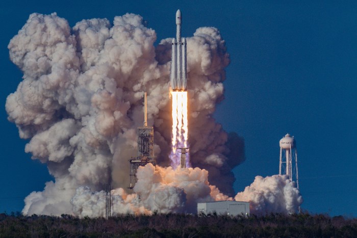 SpaceX Falcon Heavy rocket launch with massive smoke plume