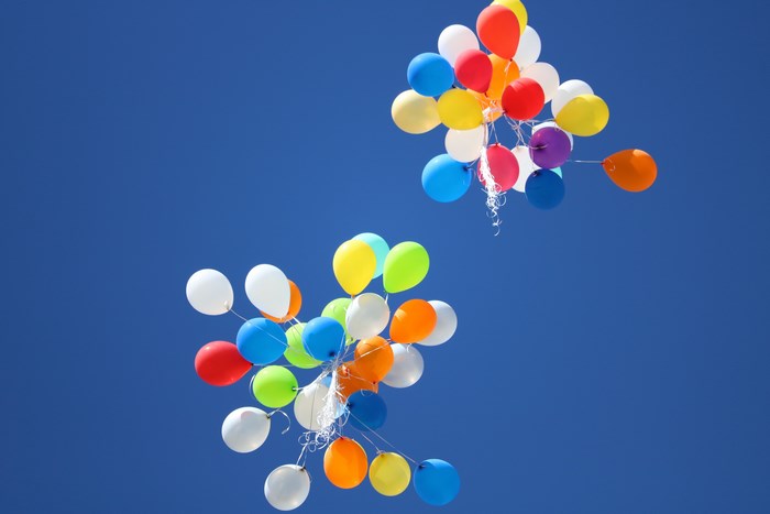 Colorful balloons flying in a clear blue sky