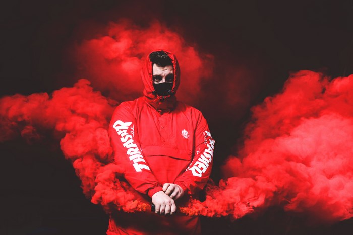Man in red Thrasher hoodie with red smoke