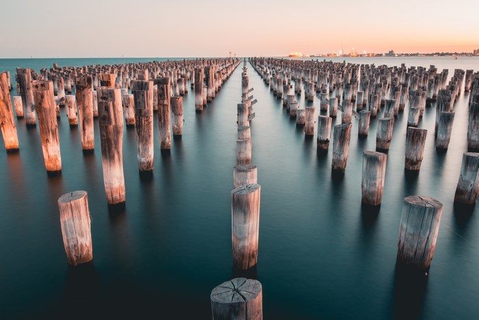 Wooden pilings in the ocean at sunset