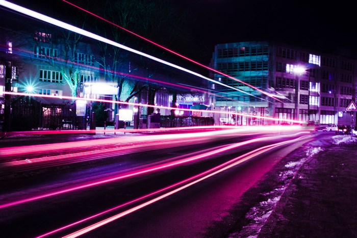 Neon light trails on a city street at night