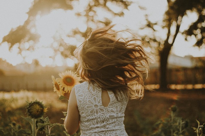 Girl in a sunflower field at sunset