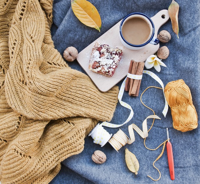Autumn flatlay with coffee, cake, and knitting supplies