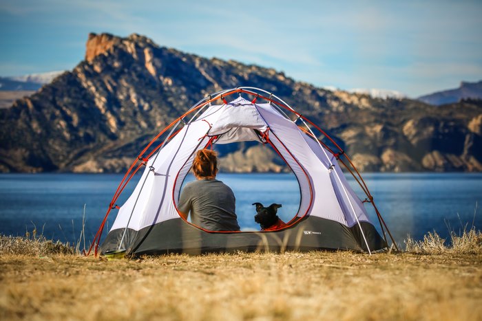 Woman and Dog Camping by Mountain Lake
