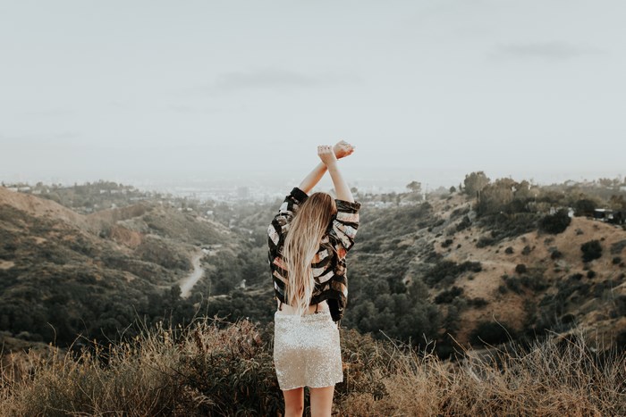 Woman in sequin skirt and jacket overlooking Los Angeles