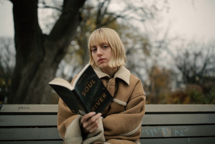 Woman reading a book on a park bench