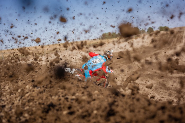 Motocross rider kicking up dirt and mud