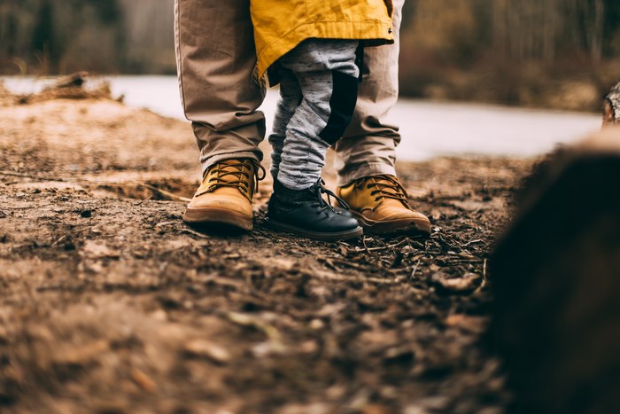 Parent and child standing on muddy ground