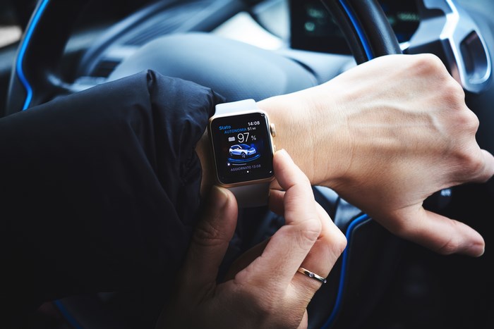 Person checking Apple Watch in a BMW i3