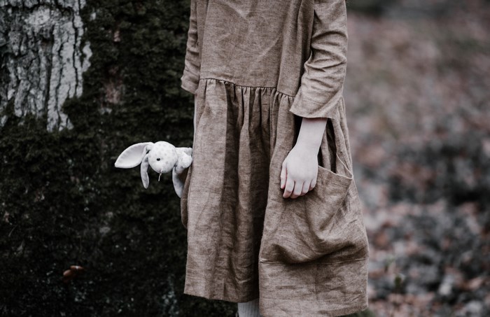 Girl holding a bunny toy in a forest