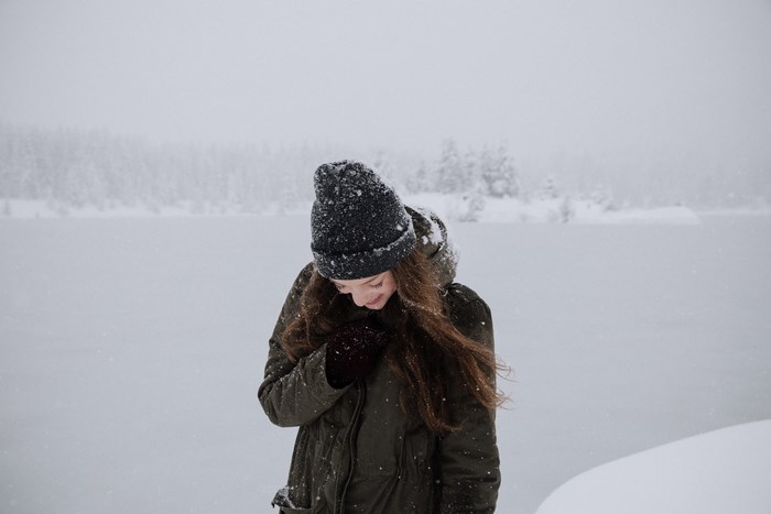 Woman in a jacket and hat in the snow