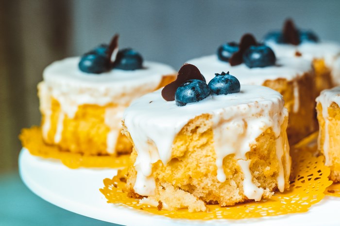 Mini cakes with blueberries and chocolate on a cake stand