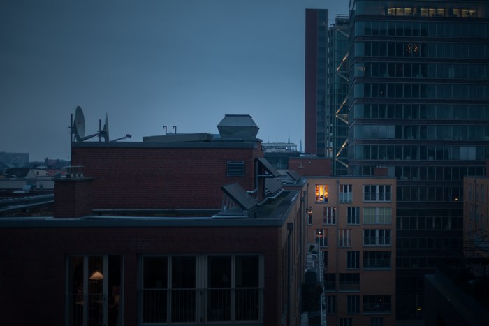 City rooftops at dusk with illuminated windows