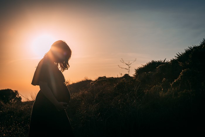 Silhouette of a pregnant woman at sunset