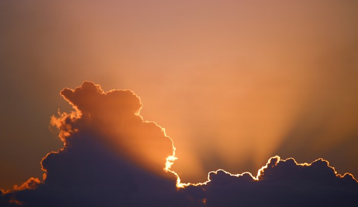 Sunlight rays behind clouds during sunset