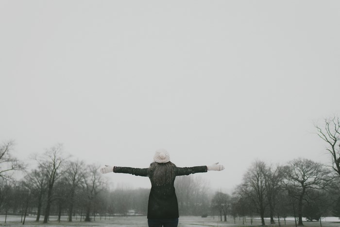 Woman with arms outstretched in the snow